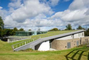 Image of the Small Animal Hospital against a blue cloudy sky and surrounded and partially covered by grass