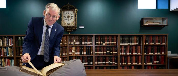 Professor Andy Schofield in the university archives with a copy of the Papal Bull created in 1490
