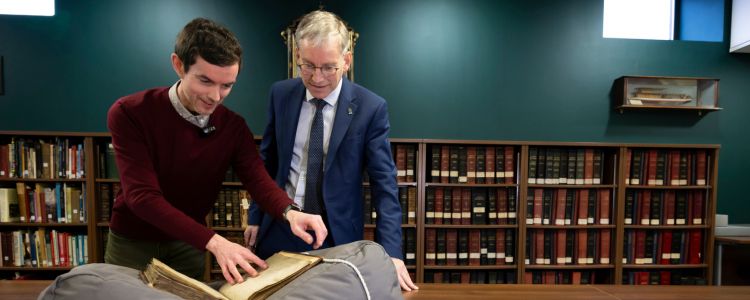 Professor Andy Schofield, Principal and Vice Chancellor, and Michael Gallagher (left), University Archivist, with a copy of the Papal Bull created in 1490