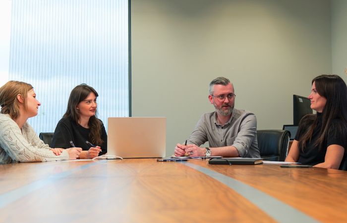 Four people sitting around a table to discuss something