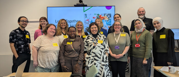 A group of people standing in a line smiling at the camera