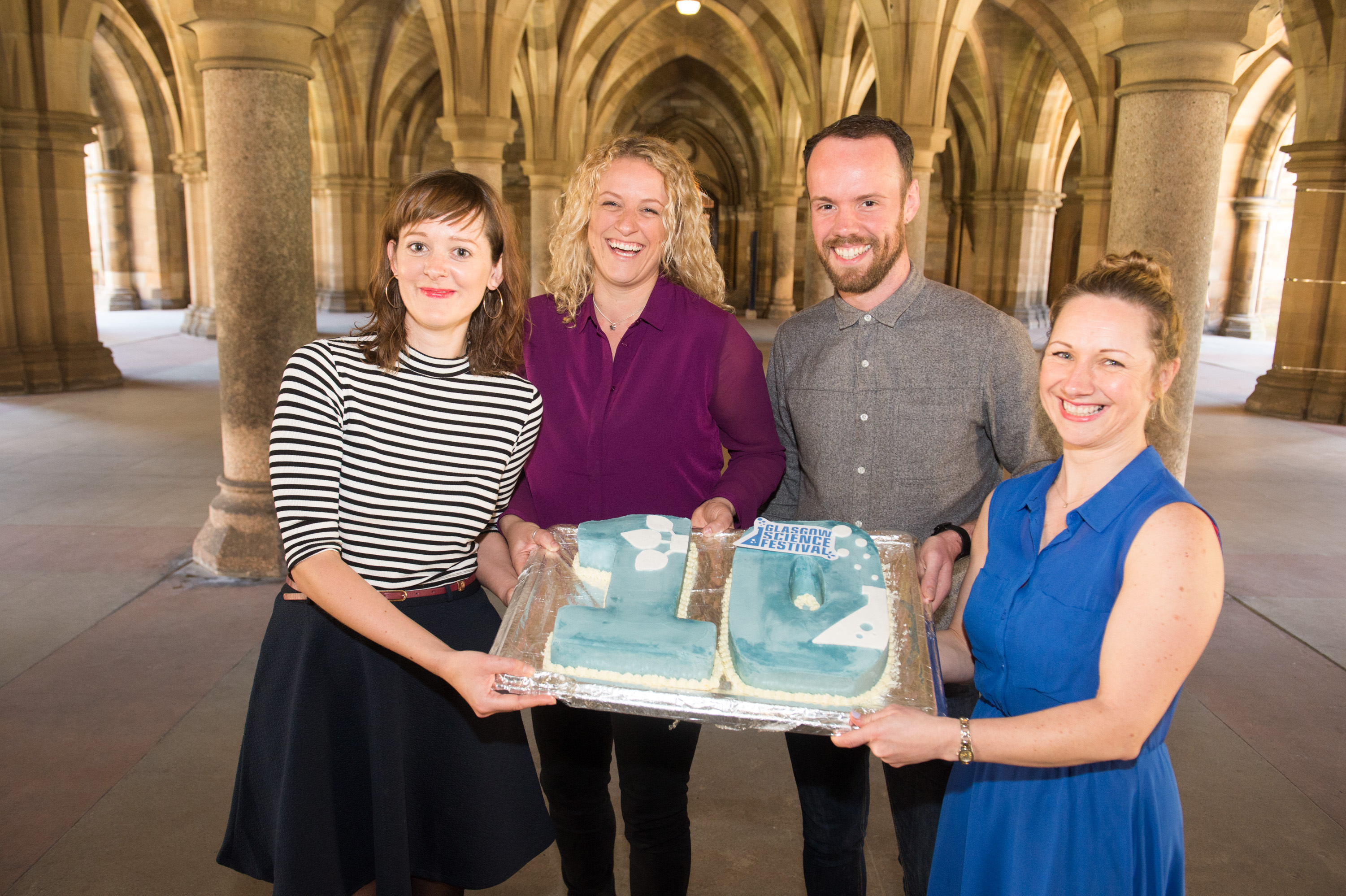 Debbie, Zara and two other people holding a cake that is a 10