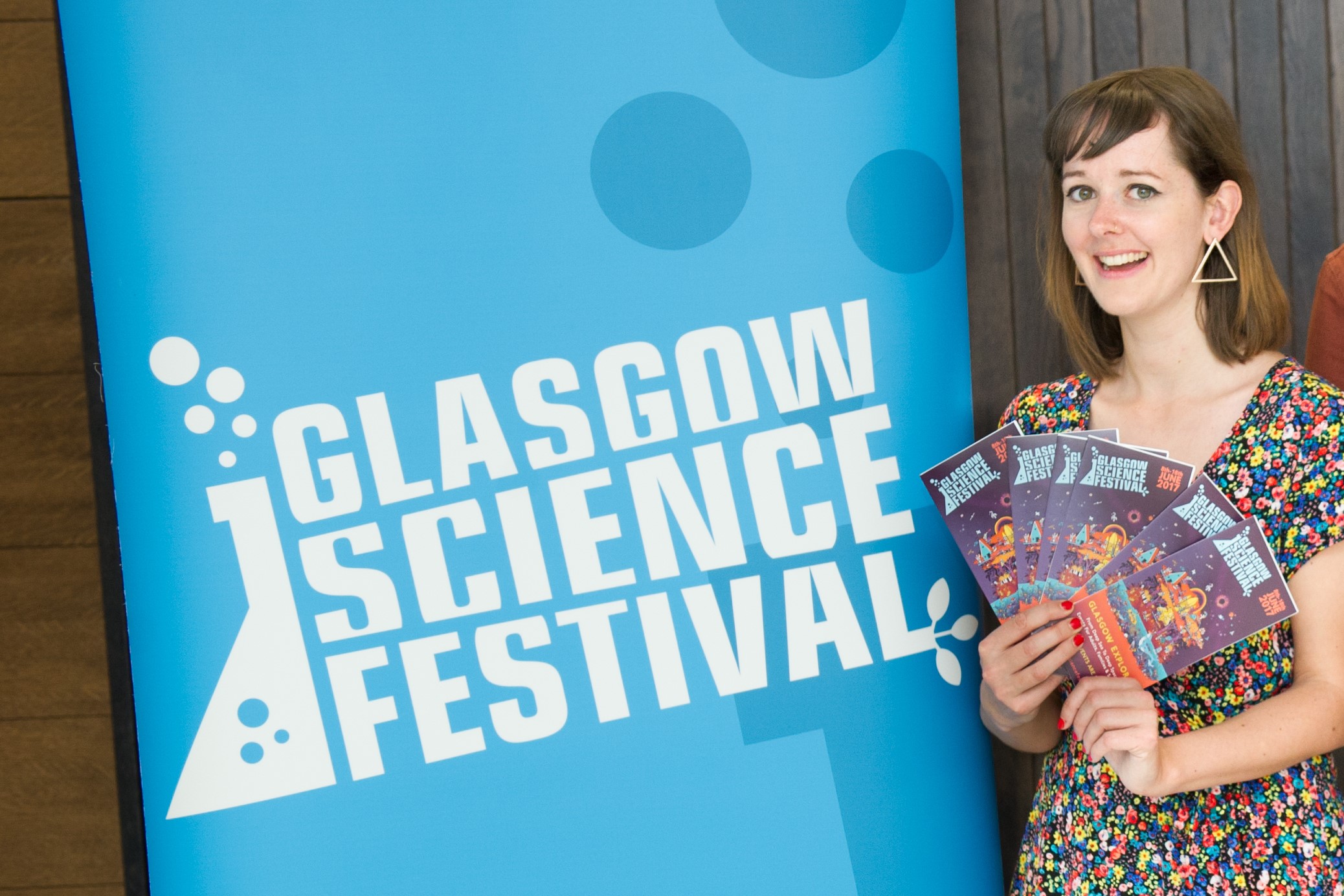 Zara Gladman standing next to a Glasgow Science Festival Banner