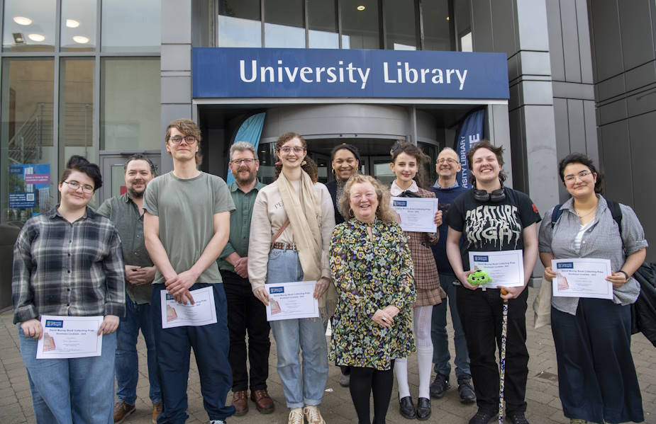 7 students holding prize certificates and 5 judges outside the University Library