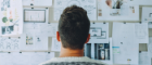 A man thinking in front of a wall of notes