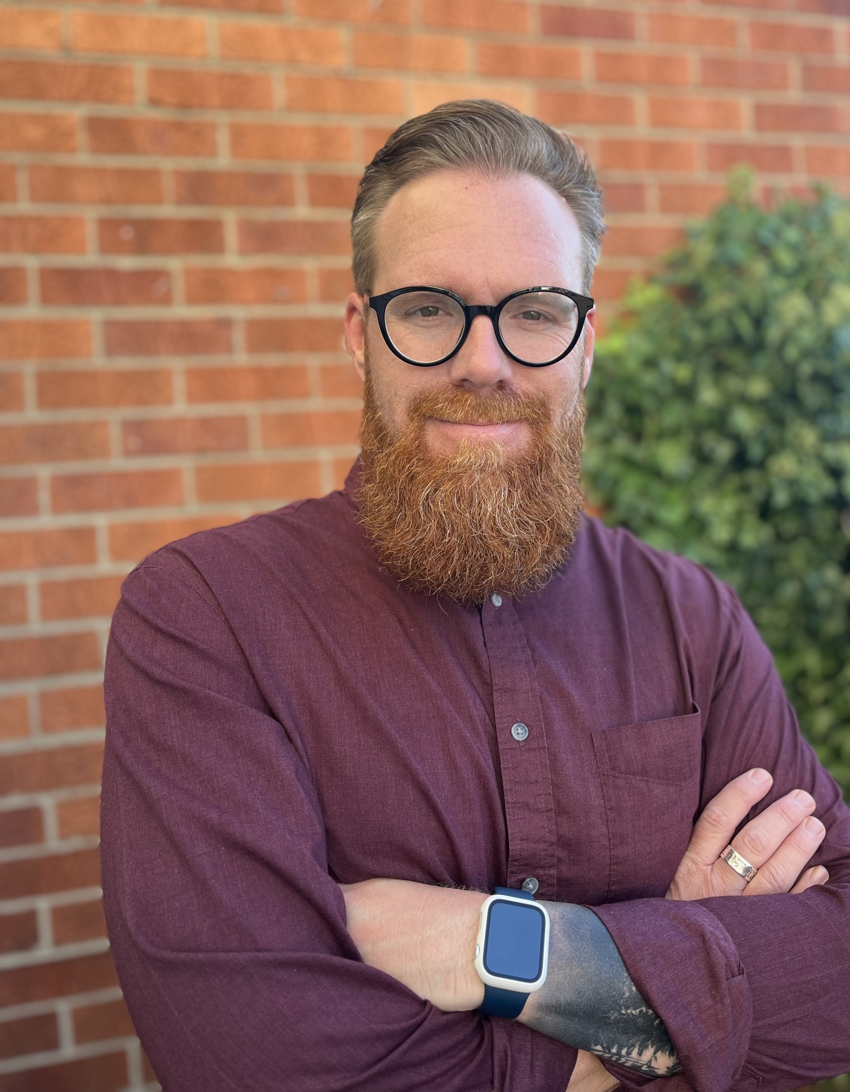A portrait of Jacob Lollar with his arms folded in front of him
