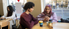 Two students sitting at a table in the GUU