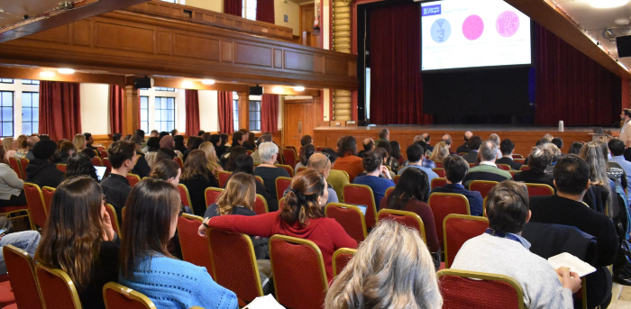 School of Infection & Immunity staff all sat together facing a speaker and screen in a theatre