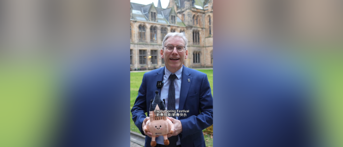Principal and Vice Chancellor Andy Schofield standing with a Gilbert Scott Tower plushie, captions at the bottom read happy spring festival