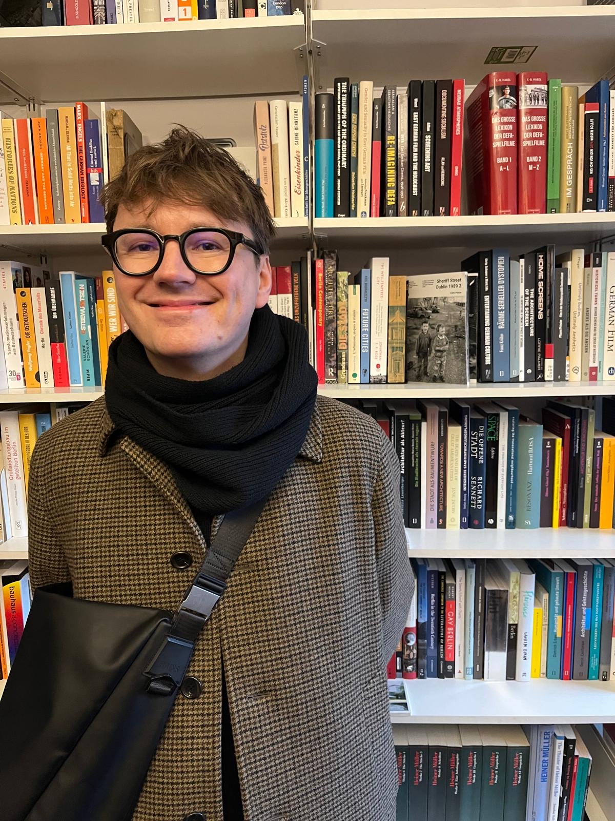 stephan ehrig standing in front of a bookshelf