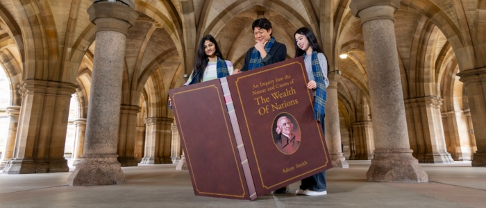 Business School Students with giant volume of Wealth of Nations