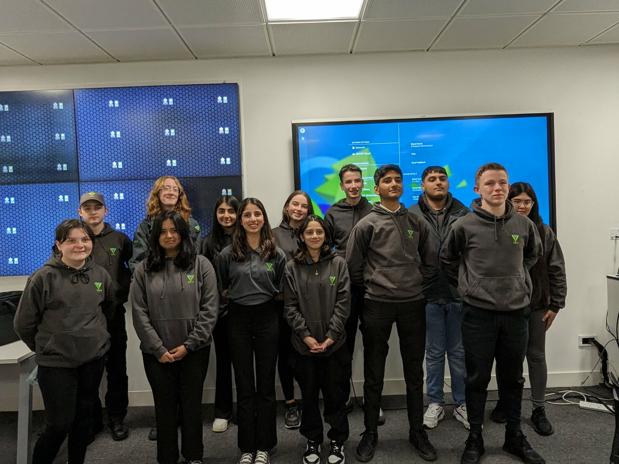 Group of Students stand together at front of a lecture theatre