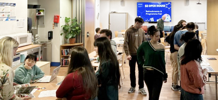 Prospective students mingle, browse stands, and talk with staff in the Sir Graeme Davies Building Common Room during the Open House event