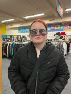 Young female student wearing sunglasses in a shop