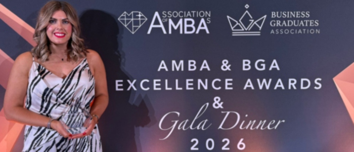 Jan Shearer holding an awards for best Partnership in front of an AMBA and BGA Excellence Awards banner
