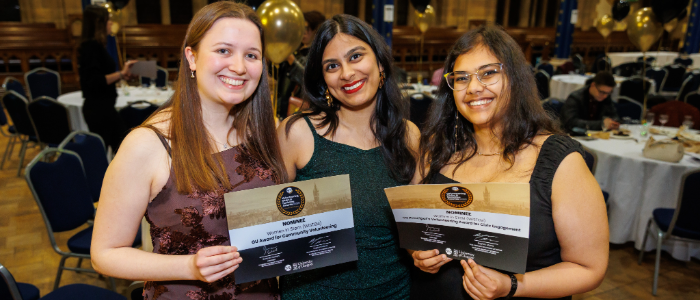 three students holding an awards each