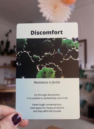 Hand holding up a card that reads 'discomfort'
