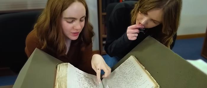 2 students examining a book from the University's special collections.