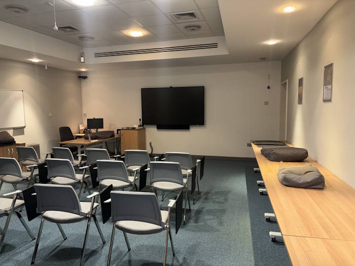 Level 12 seminar room, set up lecture style with chairs facing a screen