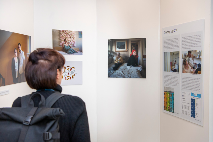 A visitor looks at hanging works at the Cost of Dying exhibition in the ARC