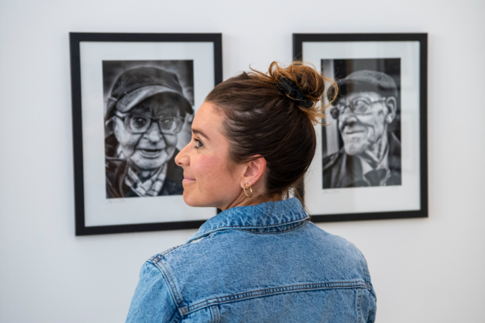 A visitor views an artwork at the Iain Clark photography exhibition in the ARC
