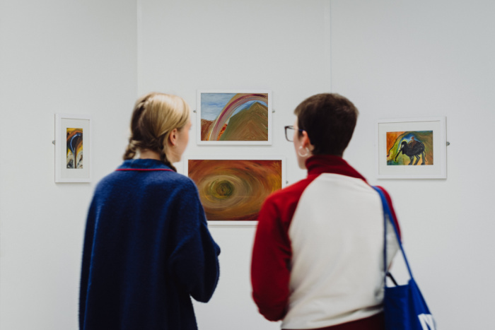 Visitors view artworks at the Mary Barnes Exhibition in the ARC