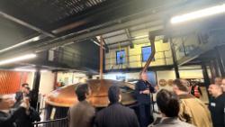 Tour group in front of copper mashtun with tour guide