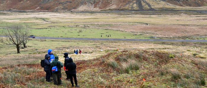 Group of students standing in remains of a building or structure
