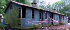 Small wooden hut at Bobbin Mill, surrounded by red tap.