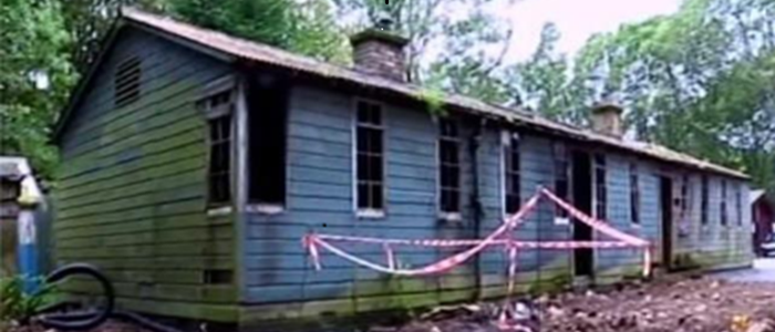 Small wooden hut at Bobbin Mill, surrounded by red tap.