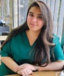 A female with long dark hair wearing a dark green dress