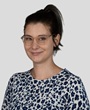 A woman wearing glasses and with dark hair in a high ponytail