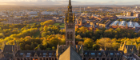 A drone photo at sunset showing the gilbert scott tower and kelvingrove park