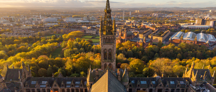 A drone photo at sunset showing the gilbert scott tower and kelvingrove park