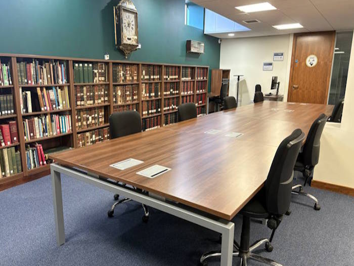 An image of the reading room at 13 Thurso Street, with some chairs around a table in the centre of the room, with shelves to the side
