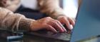 Closeup image of a woman working and typing on laptop computer