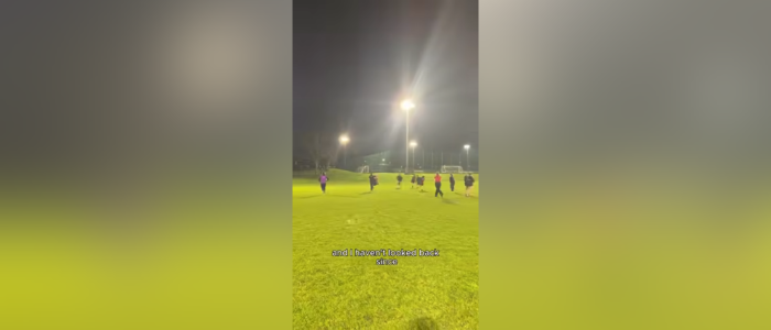 A photo of a rugby field with people playing rugby.