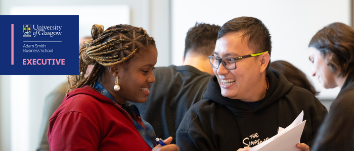 2 executive education attendees laugh during an icebreaker activity