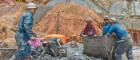 Four miners at work with a wagon outside mine