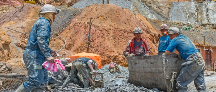 Four miners at work with a wagon outside mine