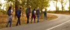 Group of friends tourists trekking with backpacks walking in the forest