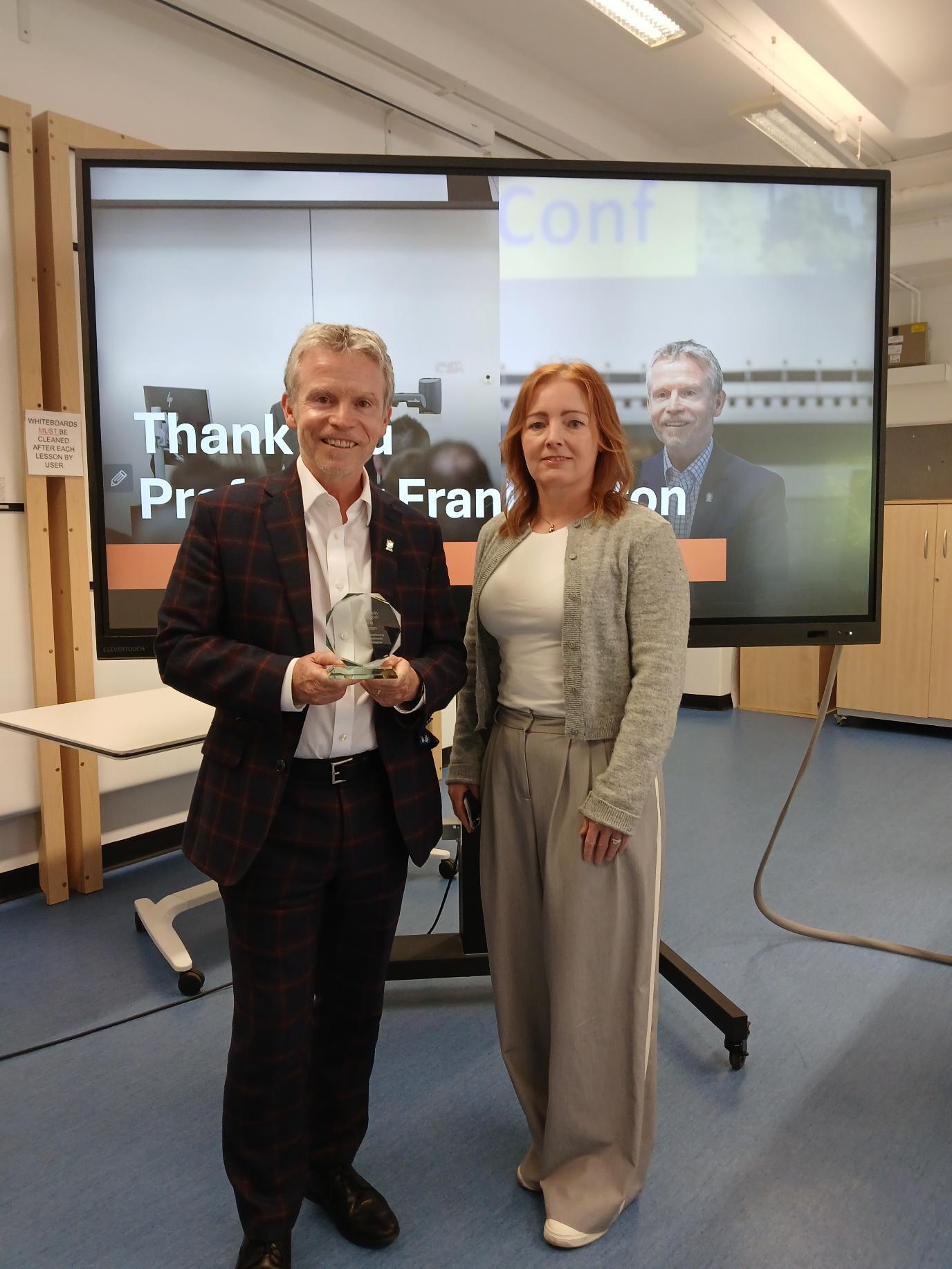 man getting award on retirement from a woman