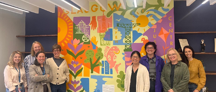 GO Justice Centre staff stand before the new mural in the main centre space