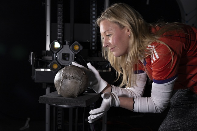Professor Pauline Mackay with the world's oldest football. Credit Martin Shields A woman wearing white gloves holds the world oldest football on a virutal reality 3D scanner. Credit Martin Shields