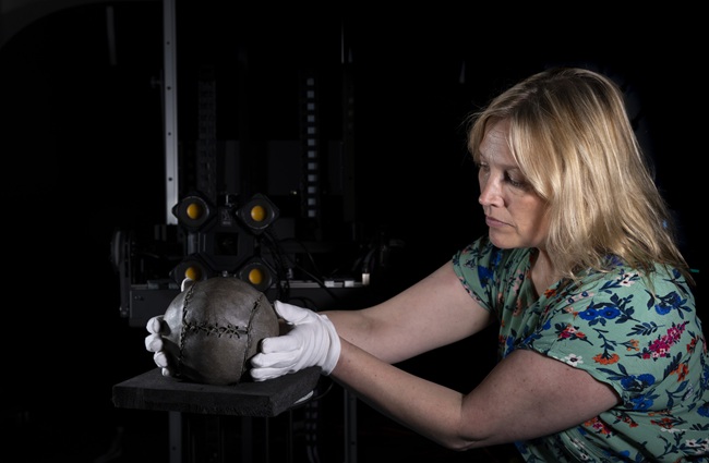 Kirstie Campbell with the world's oldest football. Credit Martin Shields A woman wearing white gloves holds the world oldest football on a virutal reality 3D scanner. Credit Martin Shields