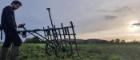 A man pushes a machine to allow him do some gradiometry surveying.