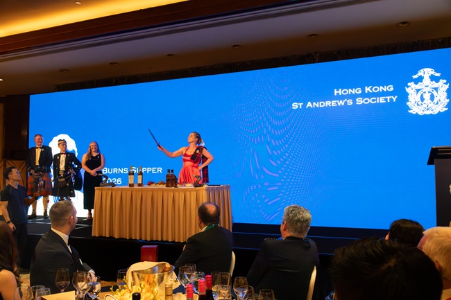 A woman stands performing at a Burns Supper at the Hong Kong St Andrews Society. Credit Nigel Baillie