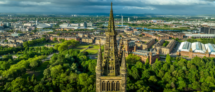 A photo of the top of the Gilbert Scott tower overlooking the city of glasgow on a sunny day
