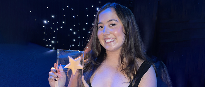 Student Joy Fallon holding an award for Star Student Marketing Award