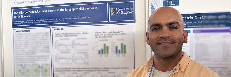 Dr Alfredo Montes Gomez stands beside his award-winning research poster at the 49th European Cystic Fibrosis Conference in Lisbon, Portugal. The poster, displayed at the University of Glasgow exhibition stand, presents research investigating the effect of Staphylococcus aureus on the lung epithelial barrier in cystic fibrosis.